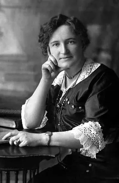 Portrait of Nellie McClung seated at a table
